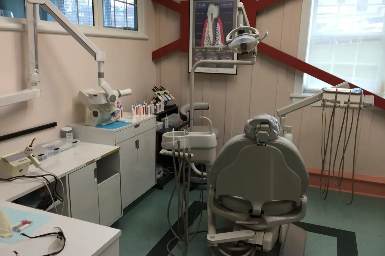 An open-air operatory at A.I.R. Dentalplex, with a treatment chair under the barn's timbered windows.
