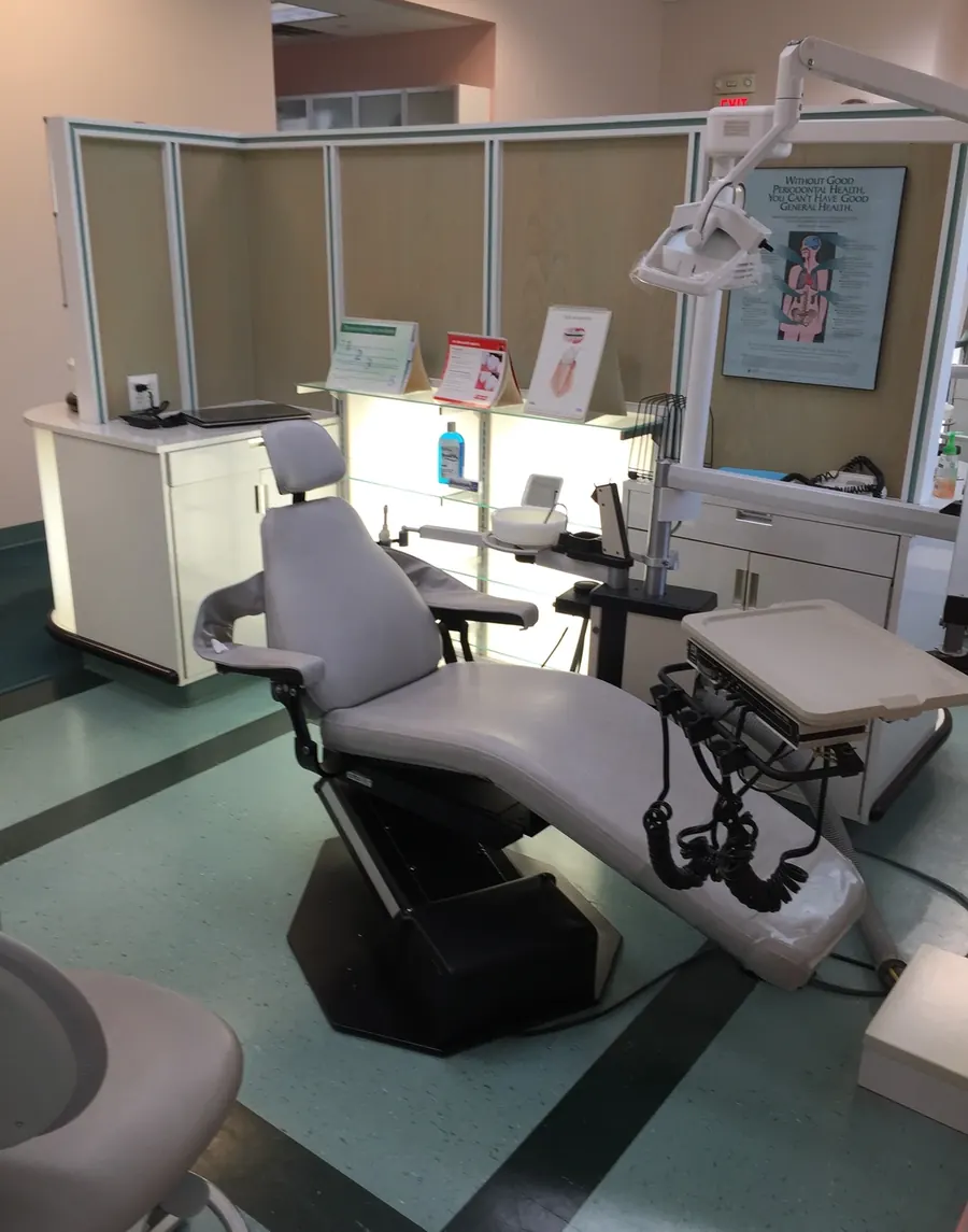 An operatory at A.I.R. Dentalplex, with the treatment chair, delivery unit and patient education posters.